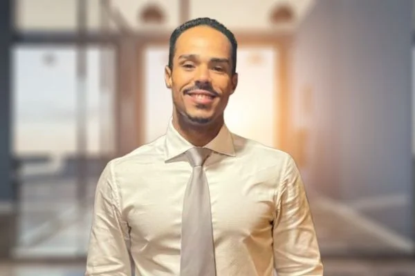 Brenner Marques sorrindo em ambiente corporativo, apresentando o Desafio Score de Milhões da Auxílio Crédito